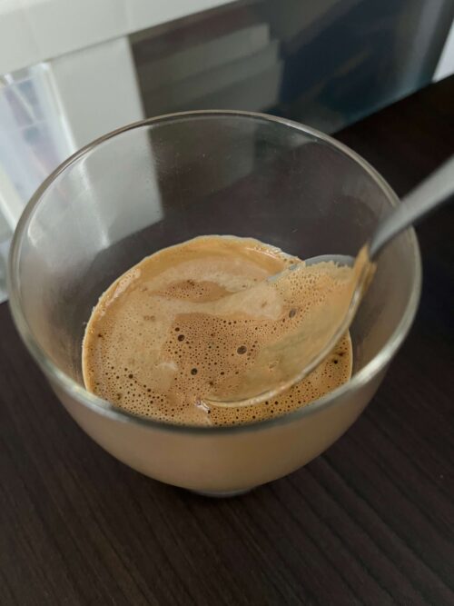 温めた牛乳の表面にできた膜の下にコーヒーホイップが入っている画像